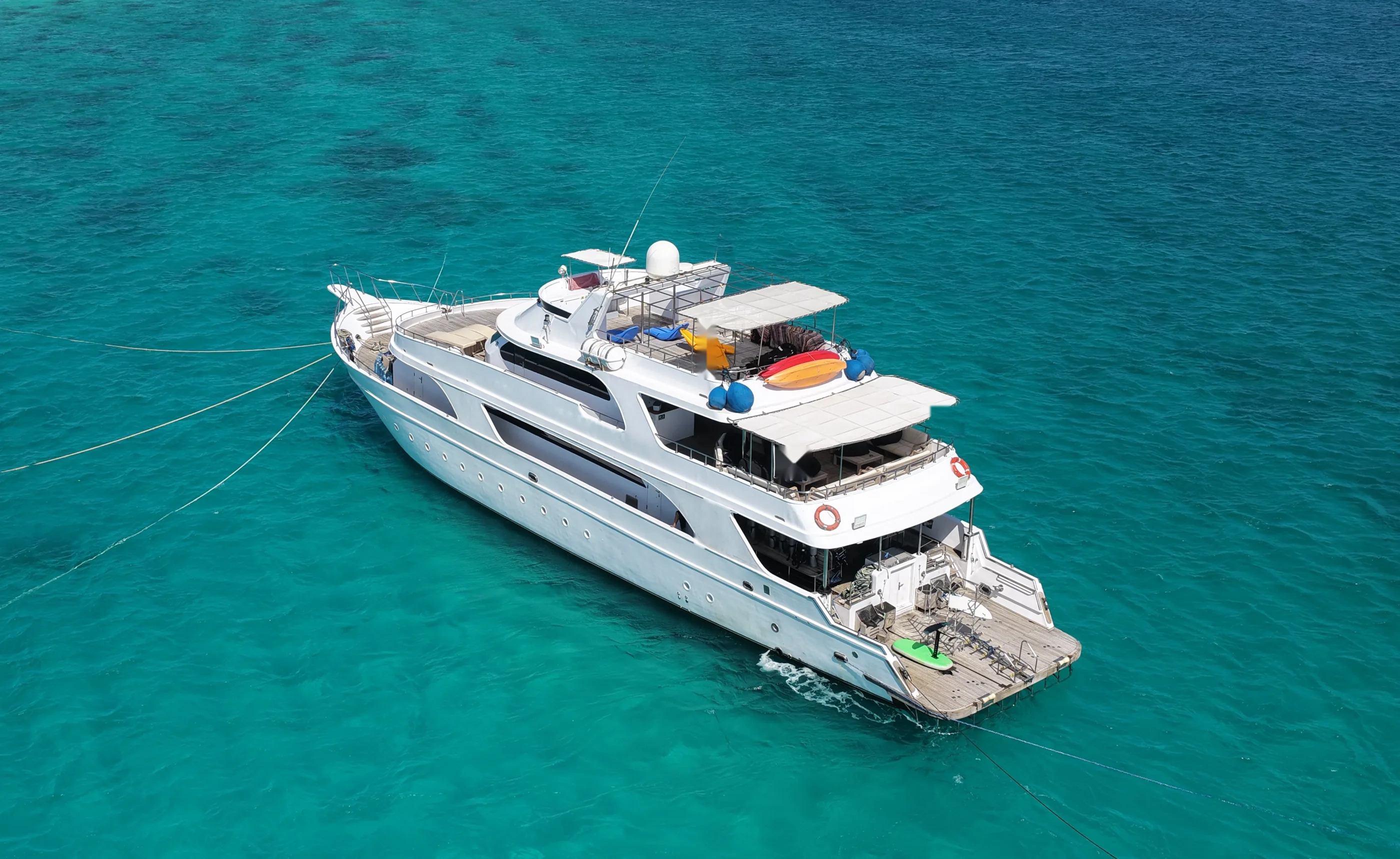 Aerial view of the liveaboard at anchor over a Red Sea reef, from astern
